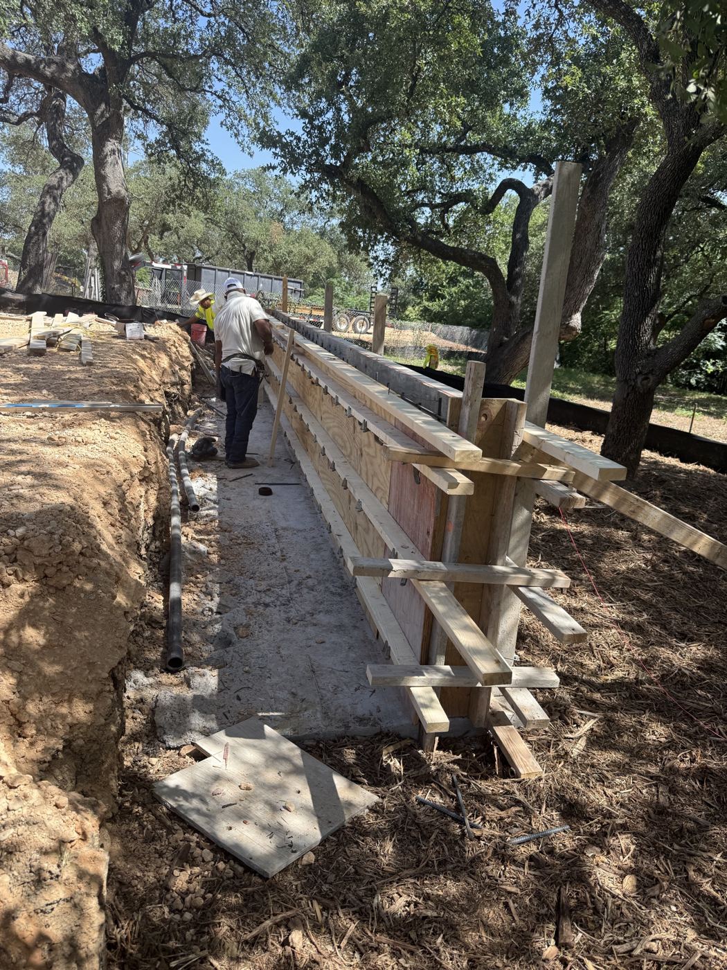 Forming the retaining wall along the tree line, Avenue N commercial site work
